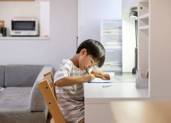 自宅の机で宿題を書く男の子