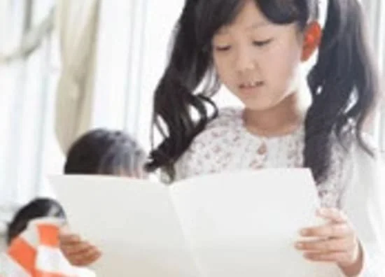 日本の小学生の女の子がクラスで読書をしている様子